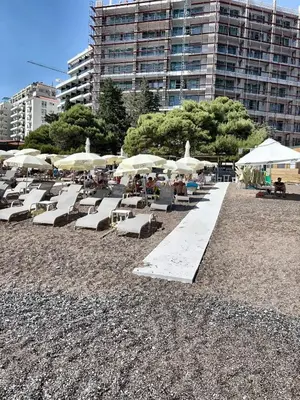 a group of lounge chairs and umbrellas on a beach at Apartment Jana Meerblick mit Balkon nähe Sandstrand in Becici