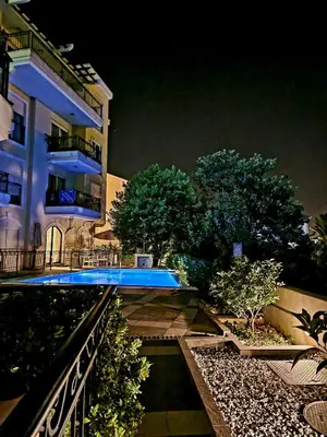 a building with a swimming pool in front of it at Posto Capitano apartment Sasa in Kotor