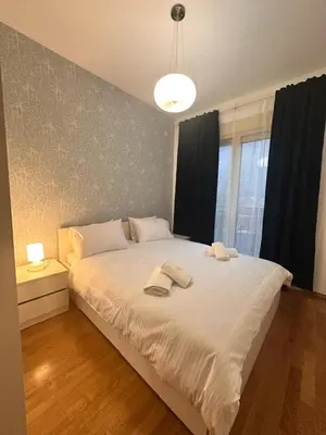 a bedroom with a large bed with two towels on it at Posto Capitano apartment Sasa in Kotor