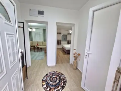 a hallway with a door leading to a living room at Podgorica Near Big Fashion in Podgorica