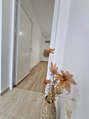 a vase with flowers in a room with a hallway at Podgorica Near Big Fashion in Podgorica