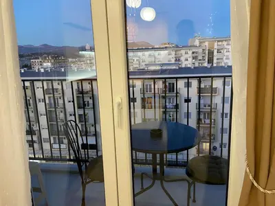 a balcony with a table and a view of a city at Cozy one bedroom apartment in Podgorica