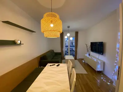 a living room with a table and a couch at Cozy one bedroom apartment in Podgorica