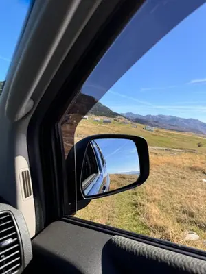 a view of a field from a car mirror at Escape Montenegro Campervan Durmitor in Podgorica