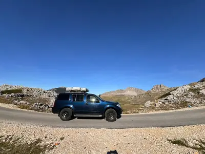 a blue suv driving down a road in the desert at Escape Montenegro Campervan Durmitor in Podgorica