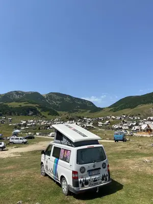 a white van parked in a field with a camper at Escape Montenegro Campervan Tranzit in Podgorica