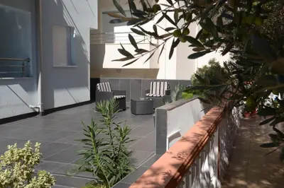 a courtyard with two chairs and plants on a building at Apartmani Barović Bečići in Becici