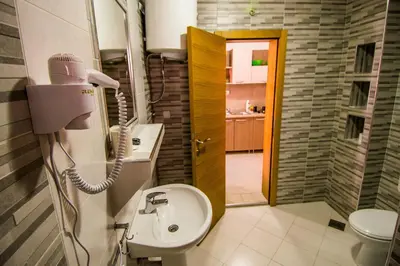 a bathroom with a sink and a toilet and a phone at Apartmani Barović Bečići in Becici