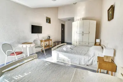 a bedroom with a bed and a table and chairs at Sun Guest House in Budva