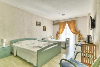 a bedroom with two beds and a television in it at Sun Guest House in Budva