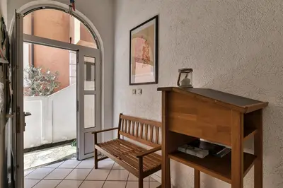 a hallway with a wooden bench and an open door at Sun Guest House in Budva