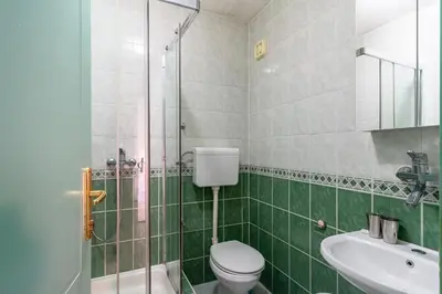 a bathroom with a shower and a toilet and a sink at Sun Guest House in Budva
