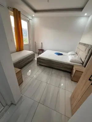 a bedroom with two beds and a large window at Apartments Bettii in Ulcinj
