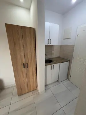 a small kitchen with a sink and a wooden door at Apartments Bettii in Ulcinj