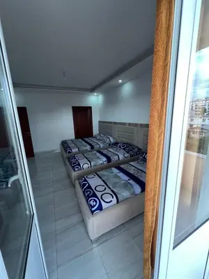 two beds in a room with a glass window at Apartments Bettii in Ulcinj