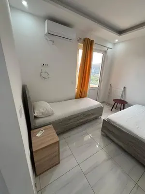 a small bedroom with two beds and a window at Apartments Bettii in Ulcinj