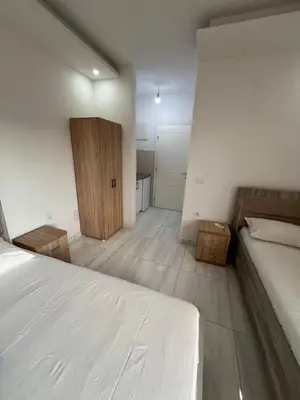 a bedroom with a white bed and a wooden door at Apartments Bettii in Ulcinj