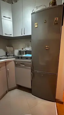 a silver refrigerator in a kitchen with white cabinets at Sunrise apartment in Podgorica