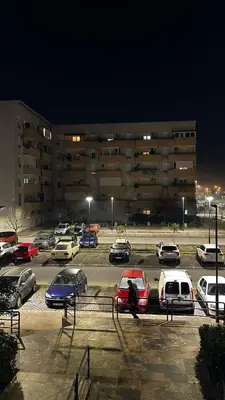 a parking lot with cars parked in front of a building at Sunrise apartment in Podgorica