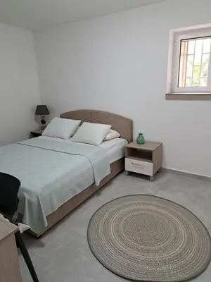 a bedroom with a large bed and a rug at Kali in Budva