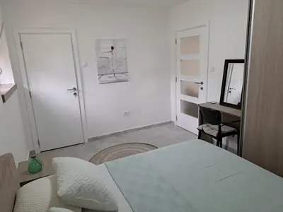 a bedroom with a bed and a desk and a mirror at Kali in Budva