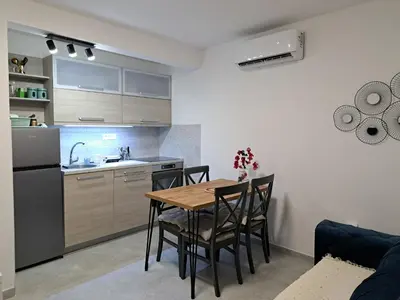a kitchen and dining room with a table and chairs at Kali in Budva
