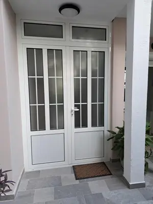 a white door with glass panels in a house at Kali in Budva