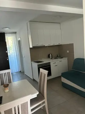 a kitchen and living room with a table and a couch at Aleksandar in Budva