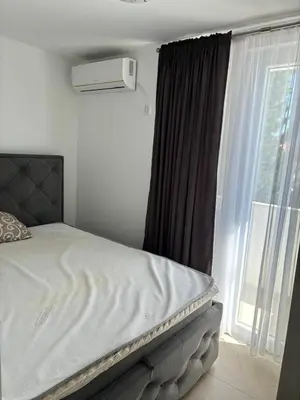 a bed in a bedroom with a large window at Aleksandar in Budva