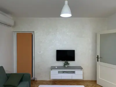 a living room with a tv on a wall at Apartman Autobuska in Podgorica