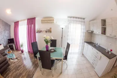 a kitchen and living room with a table and chairs at Villa Nadezda in Petrovac na Moru