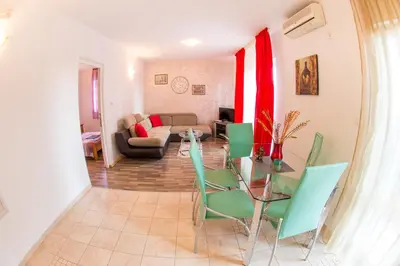 a living room with a table and green chairs at Villa Nadezda in Petrovac na Moru