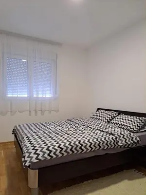a bed in a white room with a window at Gruda 086 in Cetinje