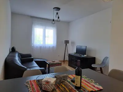 a living room with a couch and a table with a bottle of wine at Gruda 086 in Cetinje