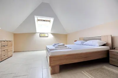 a bedroom with a large bed and a skylight at Apartments Ave R in Kotor