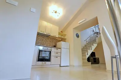 a kitchen with white appliances and a staircase at Apartments Ave R in Kotor