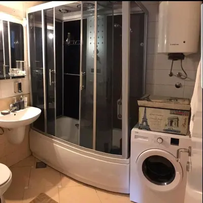 a bathroom with a shower and a washing machine at Jednosoban apartman Anara Prijevor in Budva