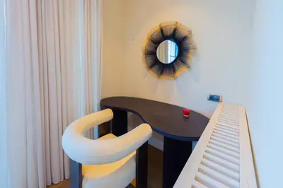 a table and a chair with a mirror on the wall at Villa Seaside Shore in Budva