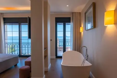 a hotel room with a tub and a view of the ocean at Villa Seaside Shore in Budva