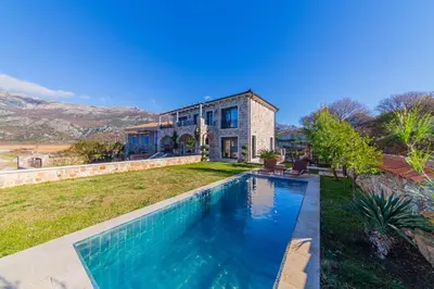 a home with a swimming pool in front of a house at Villa Seaside Shore in Budva