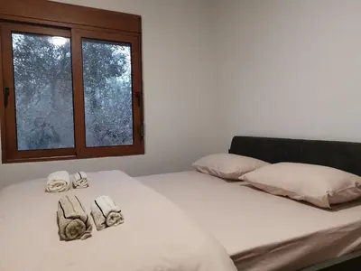 a bed with white sheets and pillows and a window at A&N Apartments in Ulcinj