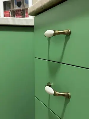 a green cabinet with two wooden handles on it at Sunny Studio Podgorica in Podgorica