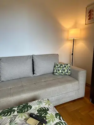 a living room with a couch and a lamp at Sunny Studio Podgorica in Podgorica