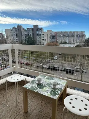 a balcony with a table and chairs and a view of a city at Sunny Studio Podgorica in Podgorica