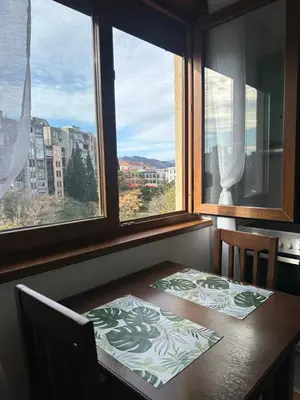 a dining room table with a view of a city at Sunny Studio Podgorica in Podgorica