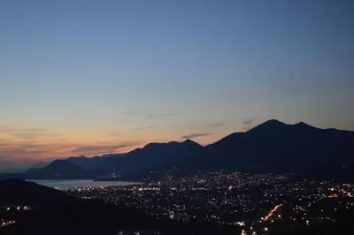 a view of a city at night with mountains at Apartments Nahla in Bar