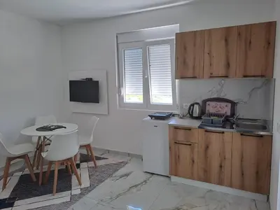a kitchen with a table and a small table and chairs at Apartments Nahla in Bar