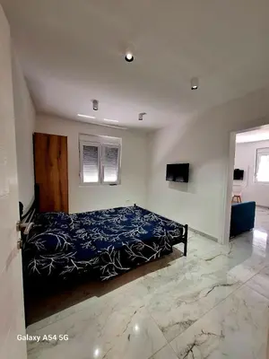 a bedroom with a bed with a blue comforter at Apartments Nahla in Bar