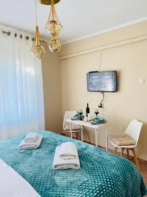 a bedroom with a bed and a table and a tv at Bella Studio in Podgorica