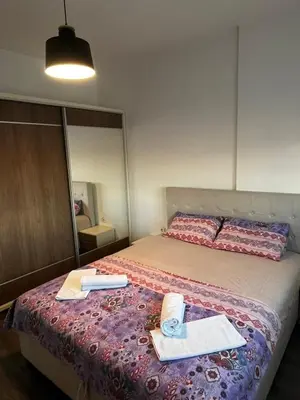 a bedroom with a bed with a mirror and towels at Amore in Ulcinj